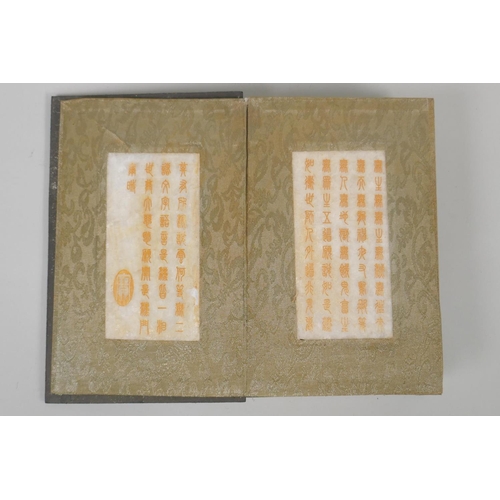 181 - A Chinese wood and silk bound book with white jade tablet pages bearing chased and gilt inscriptions... 