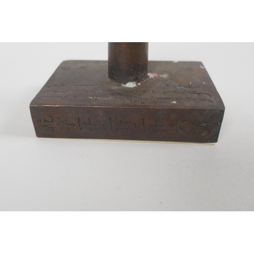 183 - A Chinese filled bronze hand seal with all over inscriptions, 9 x 6cm