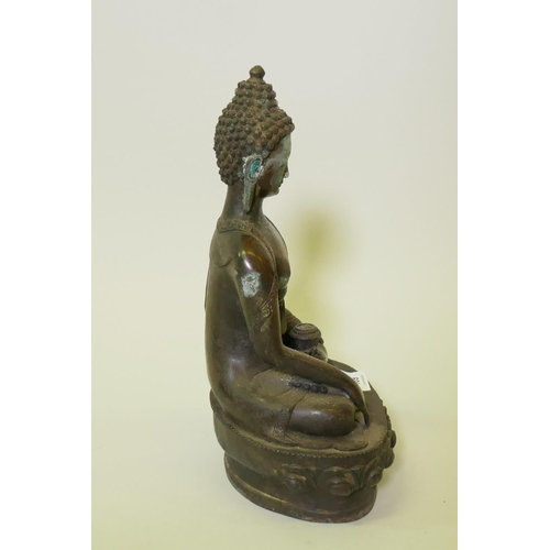 189 - An eastern bronze figure of Buddha, with brown copper patination, seated upon a lotus throne, 32cm h... 