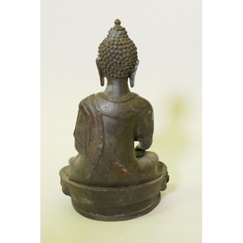 189 - An eastern bronze figure of Buddha, with brown copper patination, seated upon a lotus throne, 32cm h... 