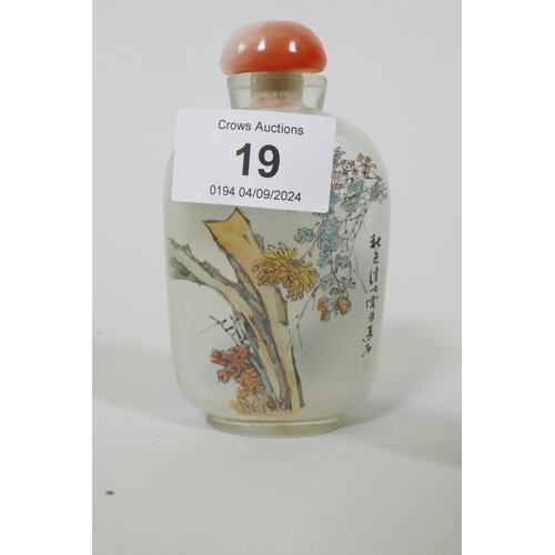 19 - A Chinese glass snuff bottle with reverse decoration of a landscape and flowering blossoms, 9.5cm hi... 