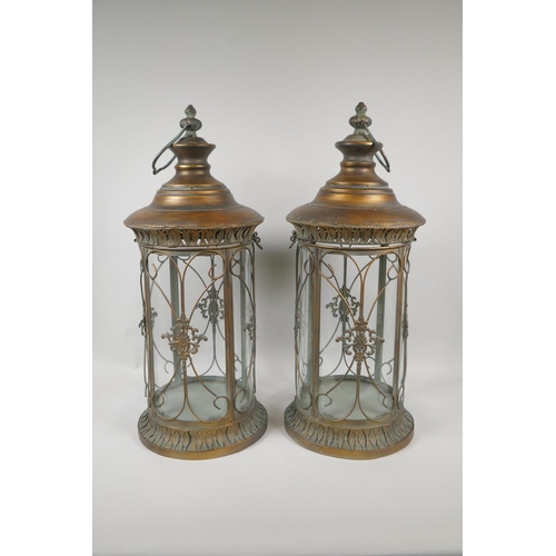 205 - A pair of gilt metal and cylinder glass lanterns, 56cm high