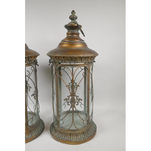 205 - A pair of gilt metal and cylinder glass lanterns, 56cm high