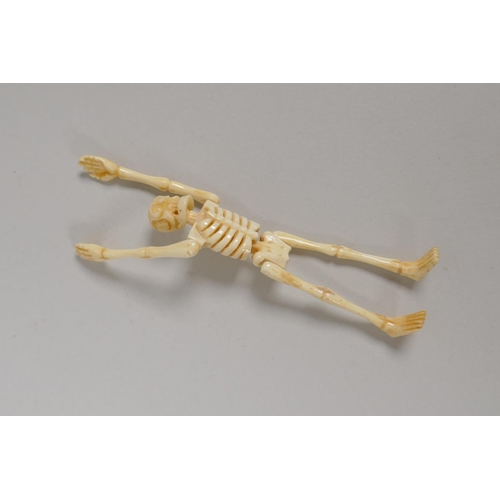 209 - A bone coffin opening to reveal a skeleton with articulated limbs, 12cm long