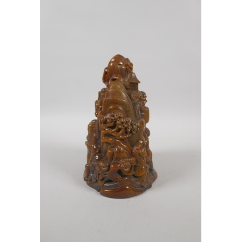 213 - A Chinese carved faux horn ornament decorated with figures in a mountain landscape, mark to base, 18... 