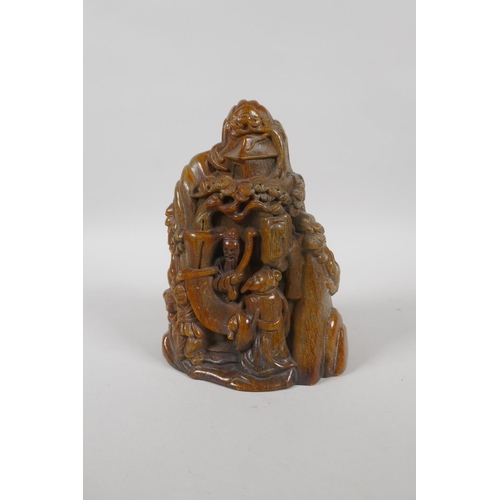 213 - A Chinese carved faux horn ornament decorated with figures in a mountain landscape, mark to base, 18... 