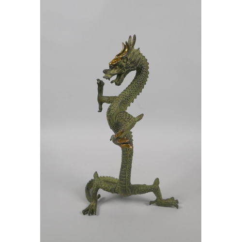 225 - A Chinese bronze figure of a dragon with gilt highlights, 24cm high