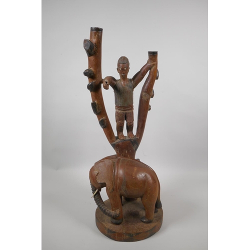 229 - An African carved hardwood lamp base in the form of a figure in a tree and an elephant, 52cm high