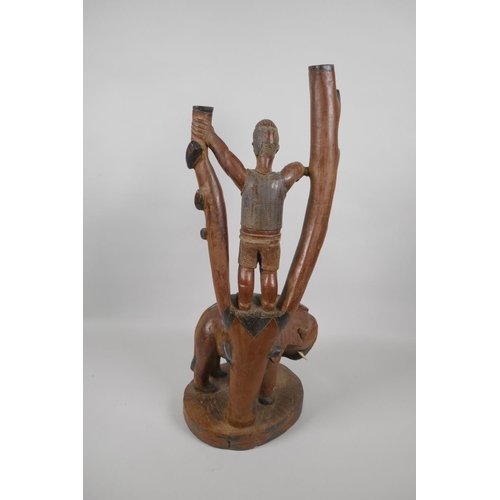 229 - An African carved hardwood lamp base in the form of a figure in a tree and an elephant, 52cm high