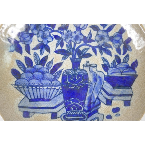 230 - A Chinese blue and white crackleware dish decorated with fruit and vases of flowers, 26cm diameter