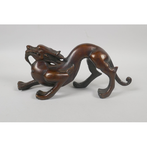 232 - A Chinese filled bronzed metal dragon, 25cm long