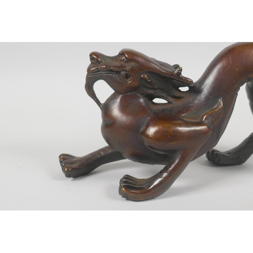 232 - A Chinese filled bronzed metal dragon, 25cm long