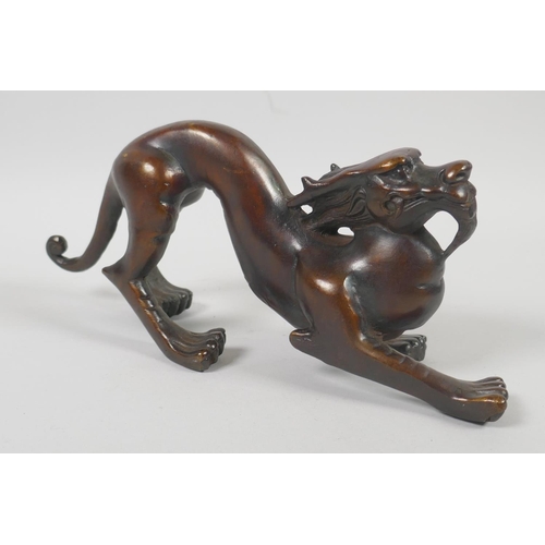 232 - A Chinese filled bronzed metal dragon, 25cm long