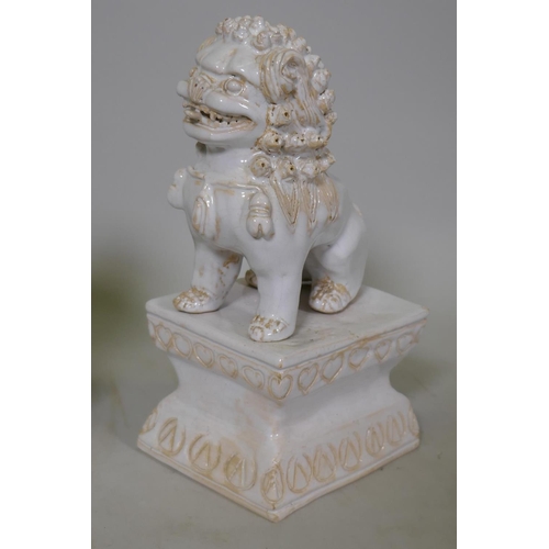 251 - A pair of white glazed terracotta figures of kylin, mounted on pedestals, 23cm high