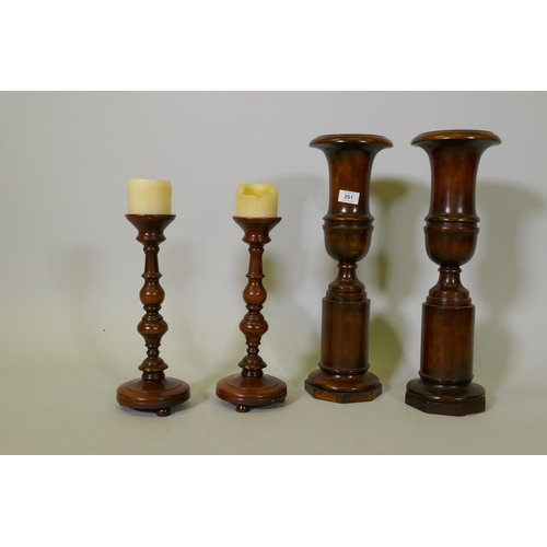 261 - A pair of turned wood decorative urns, 50cm high, and a pair of candlesticks