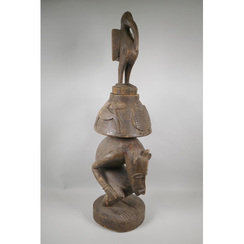 36 - An African Senufo Peoples carved wood figural offering vessel with a bird carved to the cover, 88cm ... 