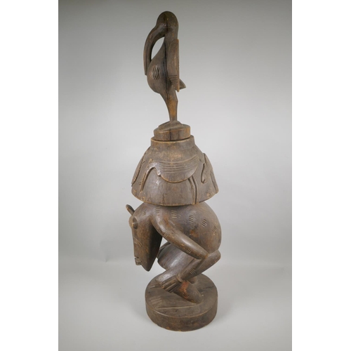 36 - An African Senufo Peoples carved wood figural offering vessel with a bird carved to the cover, 88cm ... 