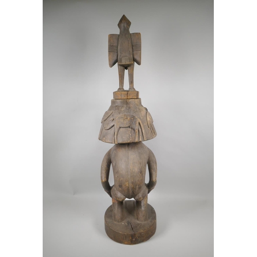 36 - An African Senufo Peoples carved wood figural offering vessel with a bird carved to the cover, 88cm ... 