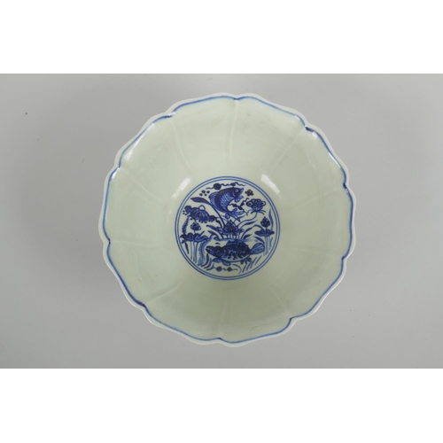 38 - A Chinese blue and white porcelain bowl with a lobed rim, decorated with carp in a lotus pond, Xuand... 