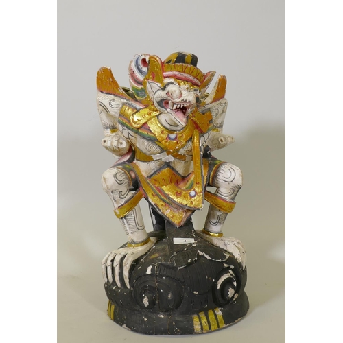 4 - A carved wood and polychrome figure of Garuda with parcel gilt decoration, 50cm high