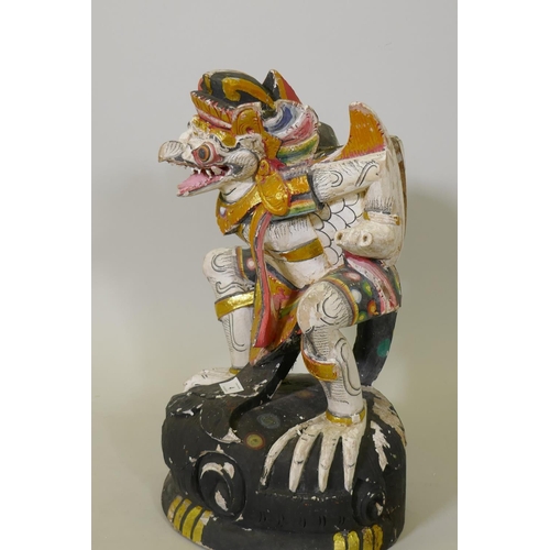 4 - A carved wood and polychrome figure of Garuda with parcel gilt decoration, 50cm high