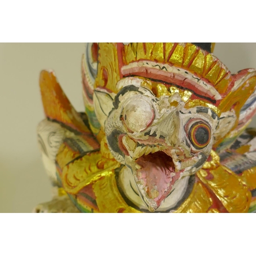 4 - A carved wood and polychrome figure of Garuda with parcel gilt decoration, 50cm high