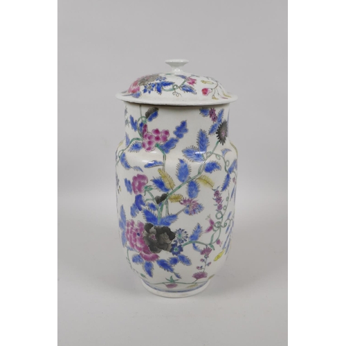 45 - An antique Oriental polychrome porcelain jar and cover, with all over floral decoration, 26cm high