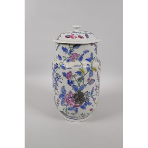 45 - An antique Oriental polychrome porcelain jar and cover, with all over floral decoration, 26cm high