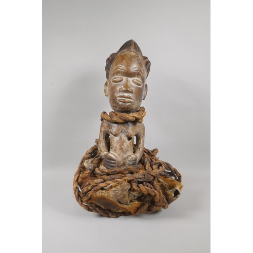 57 - An African carved wood figure bound in rope and animal fur, probably from Gabon, 45cm high