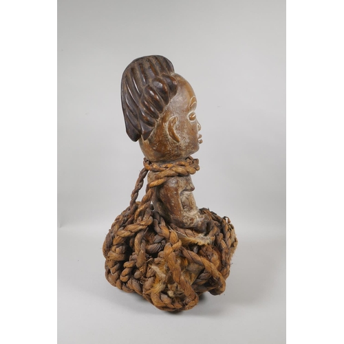 57 - An African carved wood figure bound in rope and animal fur, probably from Gabon, 45cm high