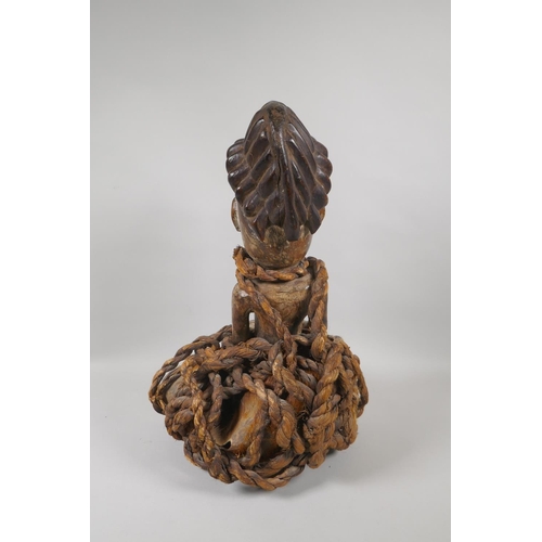 57 - An African carved wood figure bound in rope and animal fur, probably from Gabon, 45cm high