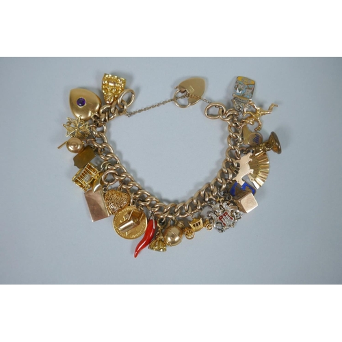 605 - A 9ct gold charm bracelet with numerous 9ct, 14ct, 18ct and 22ct gold charms, and a few yellow metal... 