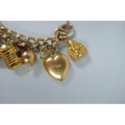 605 - A 9ct gold charm bracelet with numerous 9ct, 14ct, 18ct and 22ct gold charms, and a few yellow metal... 