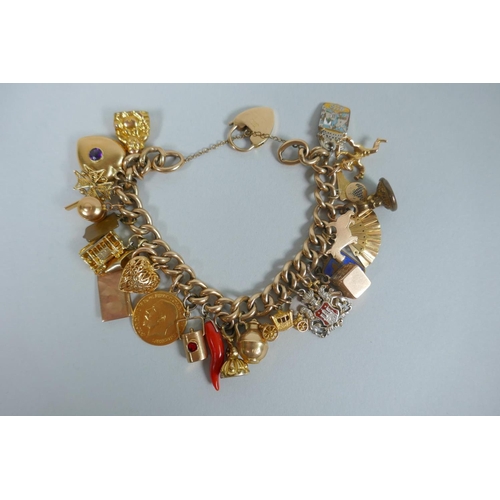 605 - A 9ct gold charm bracelet with numerous 9ct, 14ct, 18ct and 22ct gold charms, and a few yellow metal... 