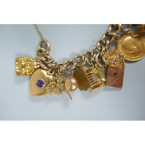 605 - A 9ct gold charm bracelet with numerous 9ct, 14ct, 18ct and 22ct gold charms, and a few yellow metal... 