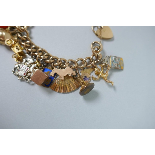 605 - A 9ct gold charm bracelet with numerous 9ct, 14ct, 18ct and 22ct gold charms, and a few yellow metal... 