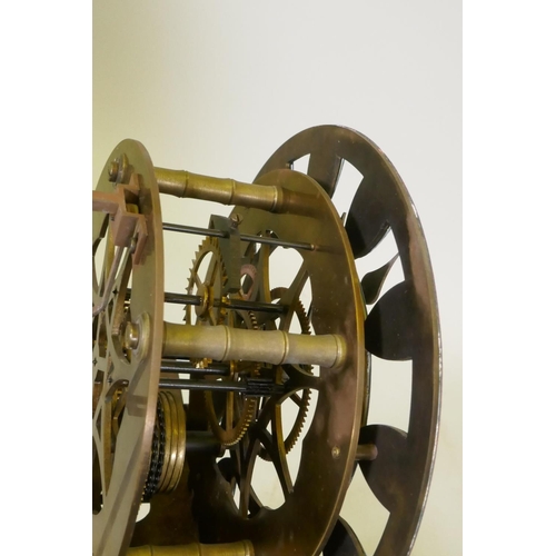 612 - A brass skeleton clock with enamel dial and single train movement, raised on a wood base with glass ... 