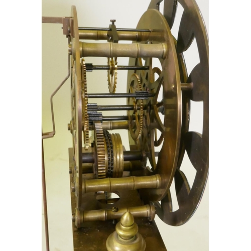 612 - A brass skeleton clock with enamel dial and single train movement, raised on a wood base with glass ... 