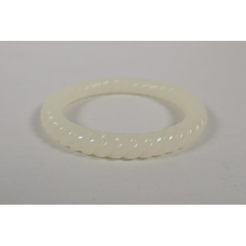 614 - A carved white jade rope twist bangle, 8cm diameter