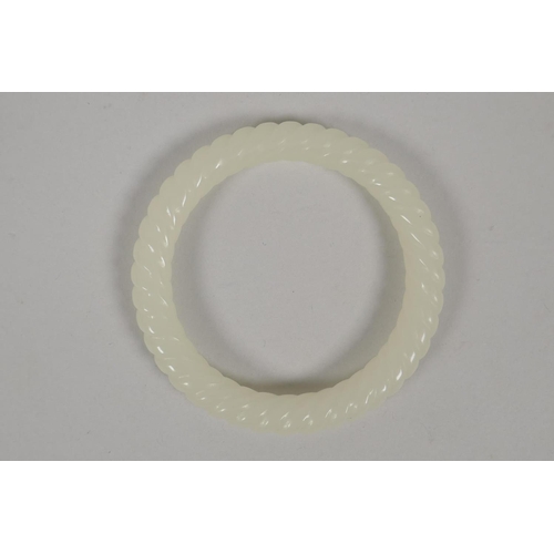 614 - A carved white jade rope twist bangle, 8cm diameter