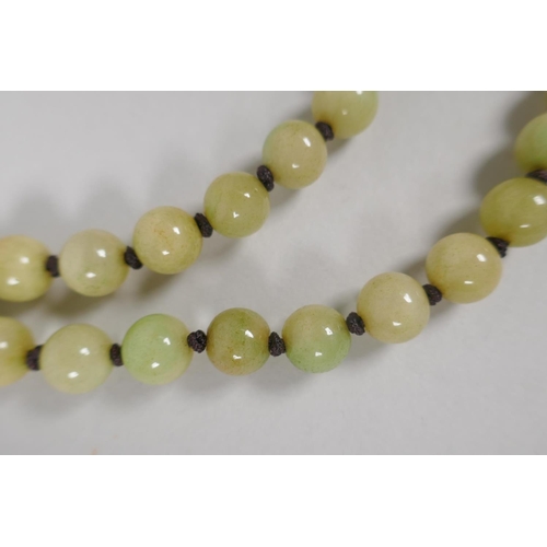 616 - A celadon jade bead necklace, 120cm