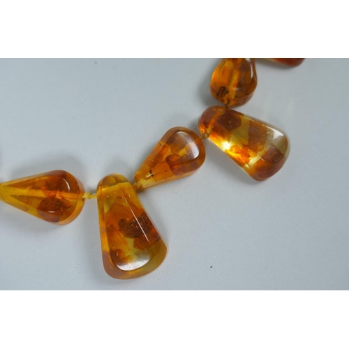 620 - A string of faceted and graduated cherry amber beads, 64g, 68cm, and a Baltic amber graduated bead n... 