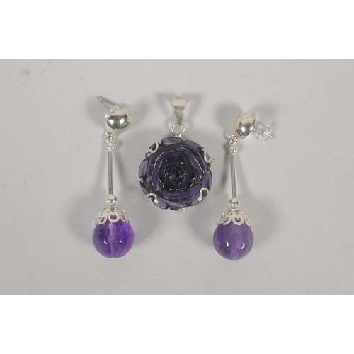 626 - A 925 silver pendant set with an amethyst coloured stone in the form of a rose, and a pair of simila... 