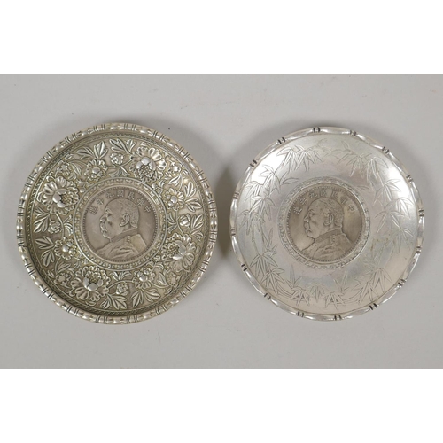 630 - A Chinese white metal coin dish with raised lotus flower decoration, and another similar with bamboo... 