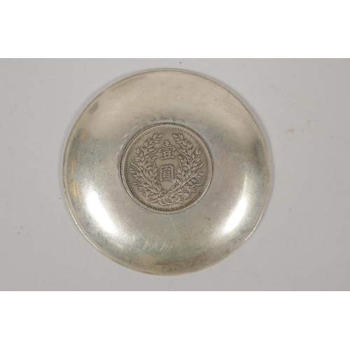 630 - A Chinese white metal coin dish with raised lotus flower decoration, and another similar with bamboo... 