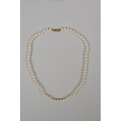 634 - A vintage pearl necklace with a 9ct gold bow shaped clasp, 42cm long