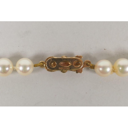 634 - A vintage pearl necklace with a 9ct gold bow shaped clasp, 42cm long