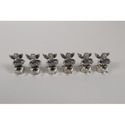 636 - Six silvered metal place name holders in the form of winged cherubs, 2.5cm high