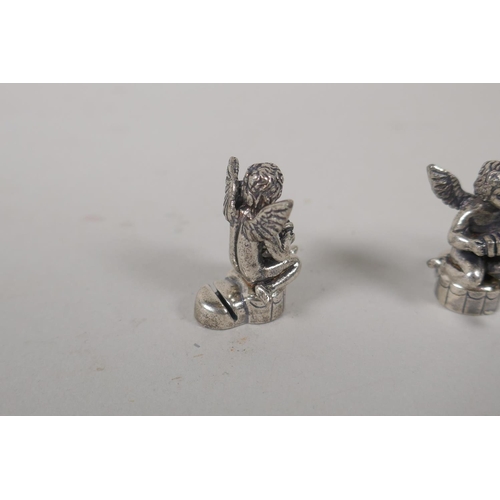 636 - Six silvered metal place name holders in the form of winged cherubs, 2.5cm high