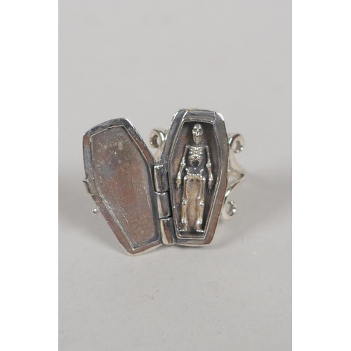 640 - A 925 silver ring set with a coffin opening to reveal a skeleton